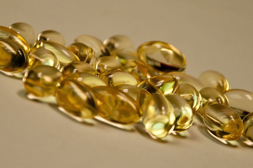 Pile of golden vitamin E softgel capsules