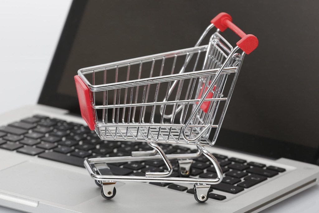 Miniature shopping cart on a laptop keyboard