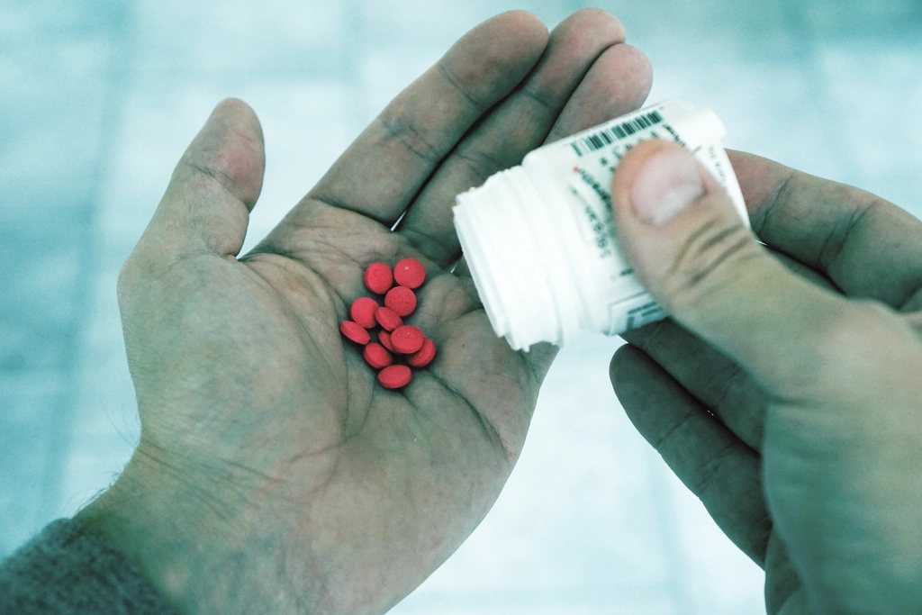Small pink tablets poured into an open palm