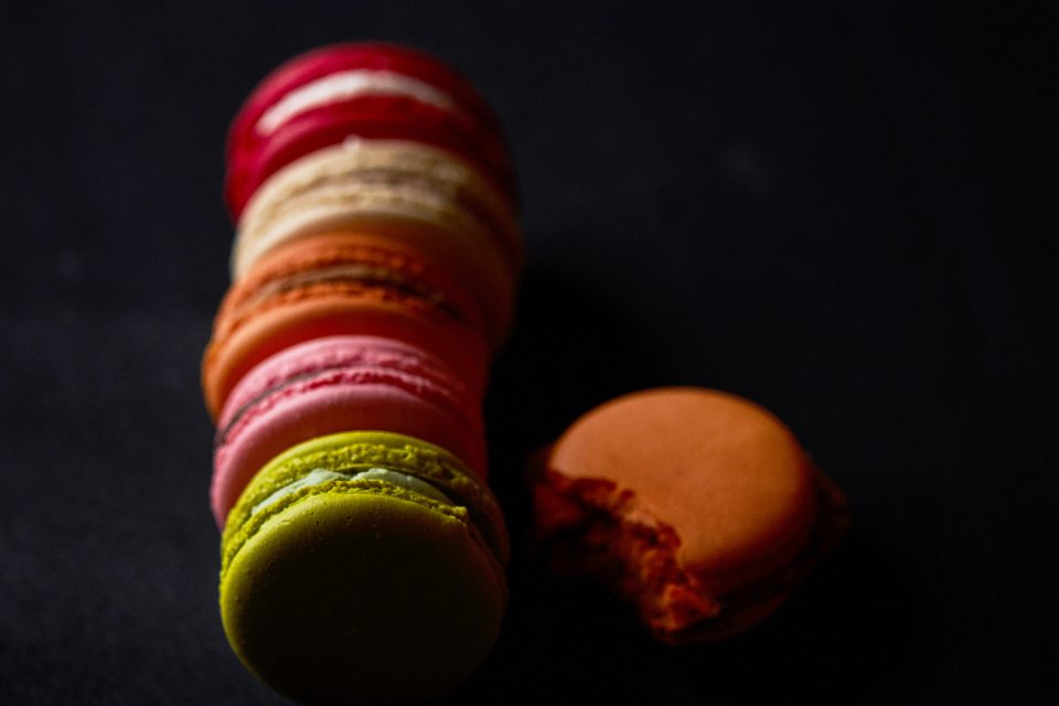 Stack of colourful macarons on a dark background