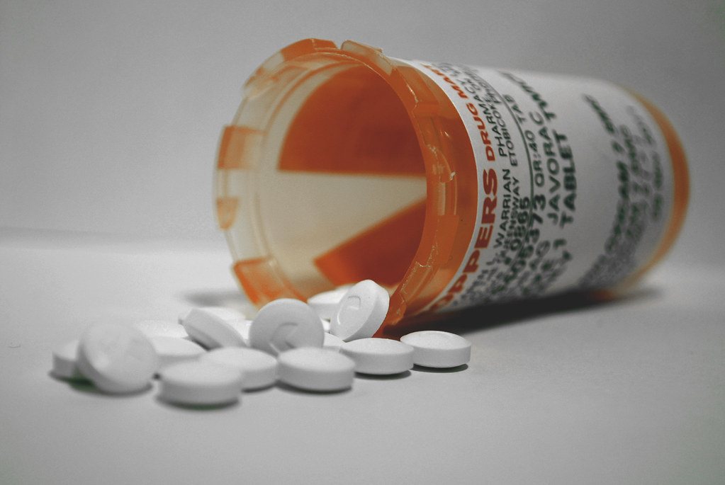 White tablets spilling from a prescription bottle