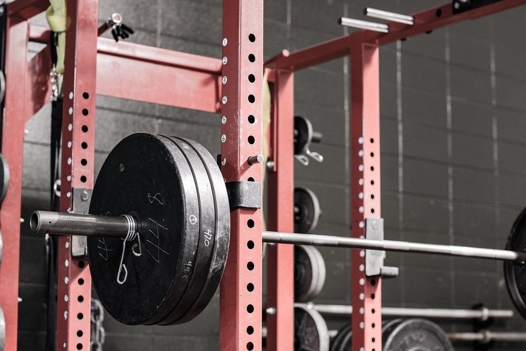 Loaded barbell resting in a squat rack